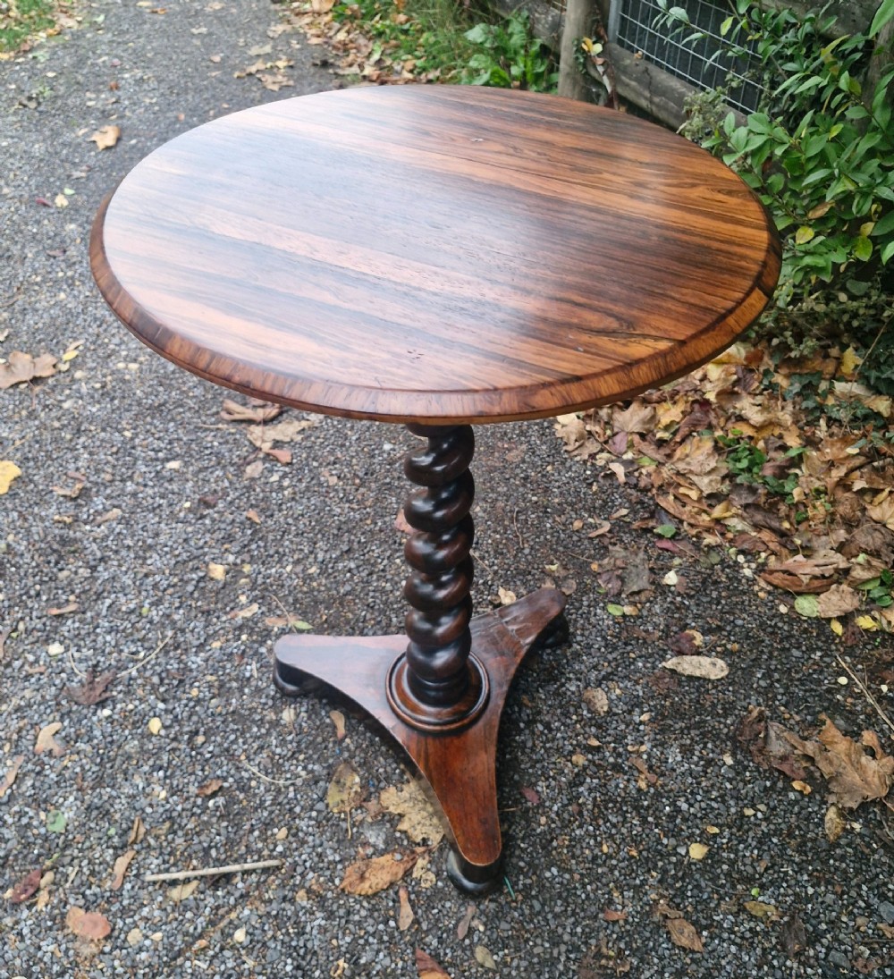 A circular mid-Victorian rosewood occasional table featuring a figured wood top, a carved spiral barley-twist central stem, and a triform platform base. View III