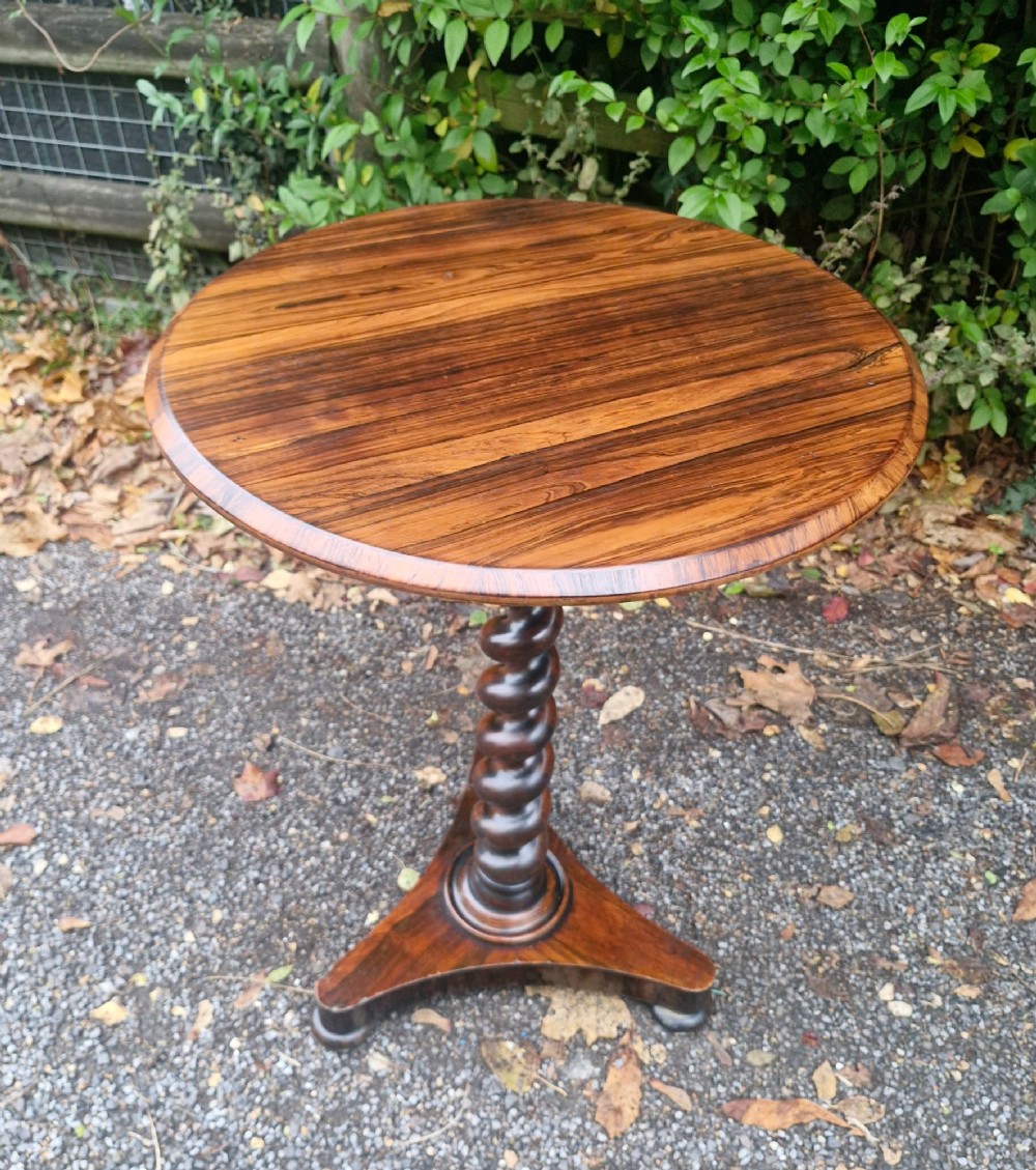 A circular mid-Victorian rosewood occasional table featuring a figured wood top, a carved spiral barley-twist central stem, and a triform platform base. View IV