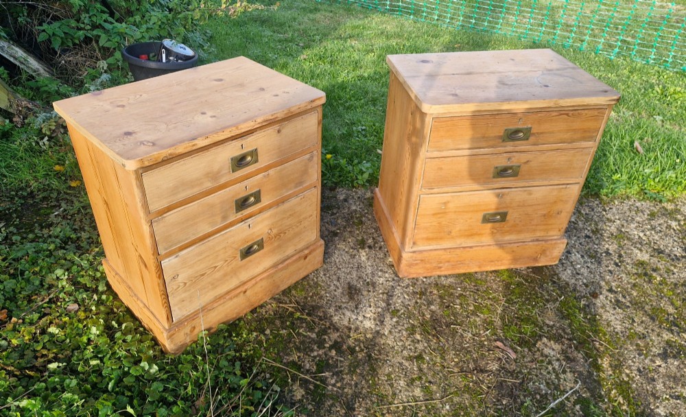 A pair of three-drawer pine bedside chests featuring recessed brass handles and plinth bases. View VI
