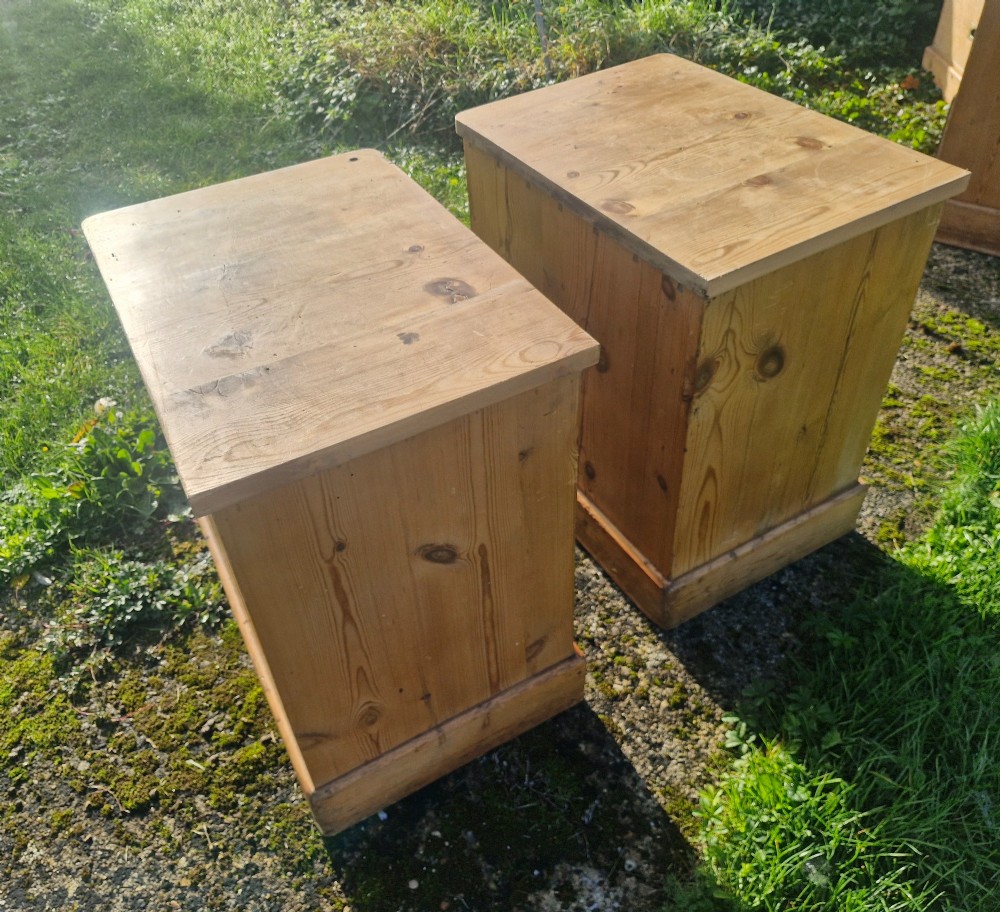 A pair of three-drawer natural pine bedside chests featuring brass flush campaign-style handles and solid plinth bases. View VII