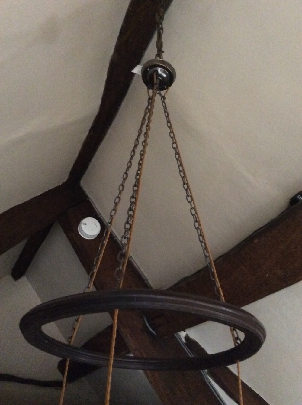 An Arts and Crafts style three-lantern ceiling light featuring a central circular dark frame suspended by chains with three hanging illuminated glass lanterns. View IV