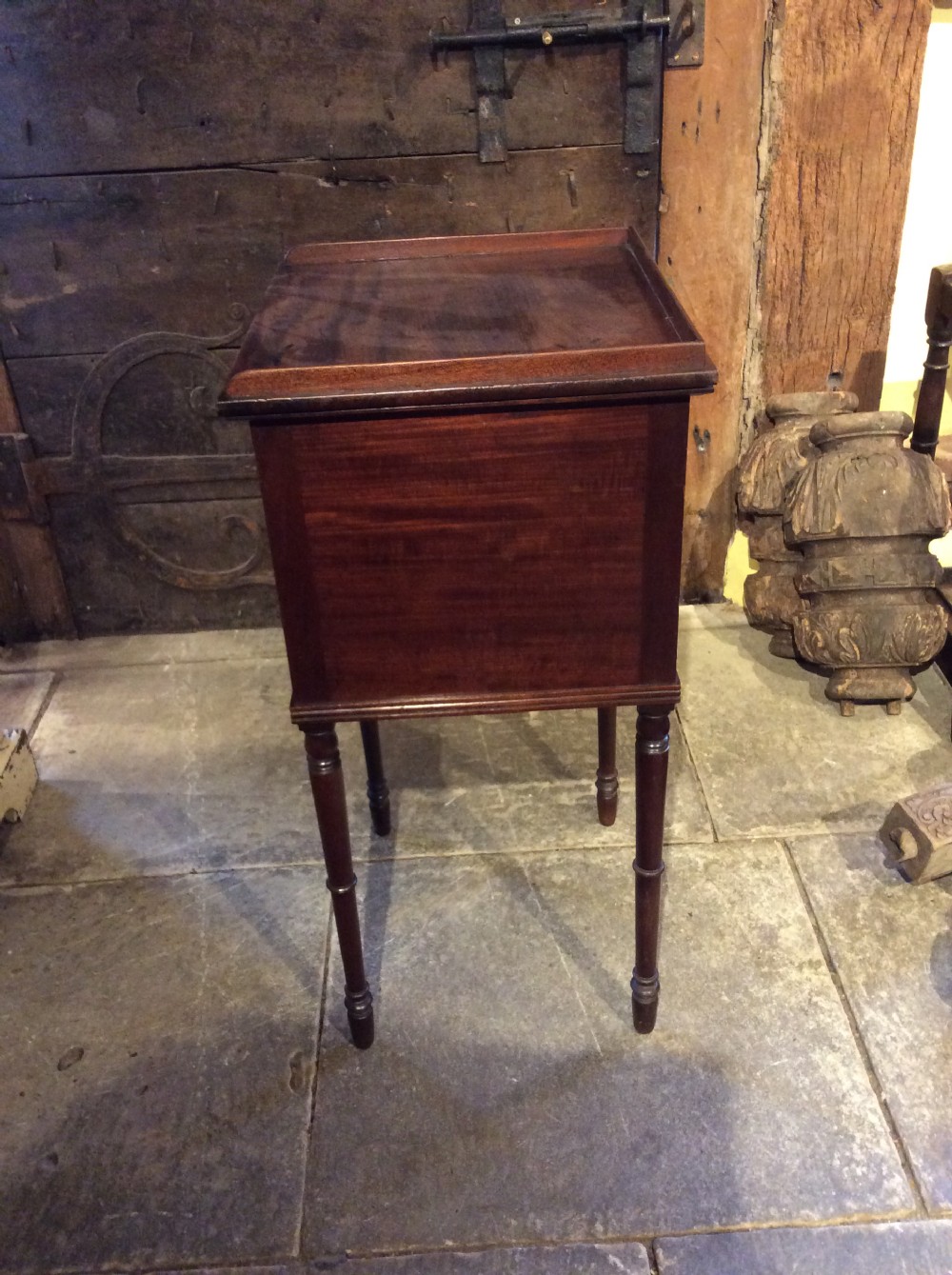 A Regency mahogany bedside cabinet featuring a gallery top, single flame mahogany door panel, and slender turned legs. View II