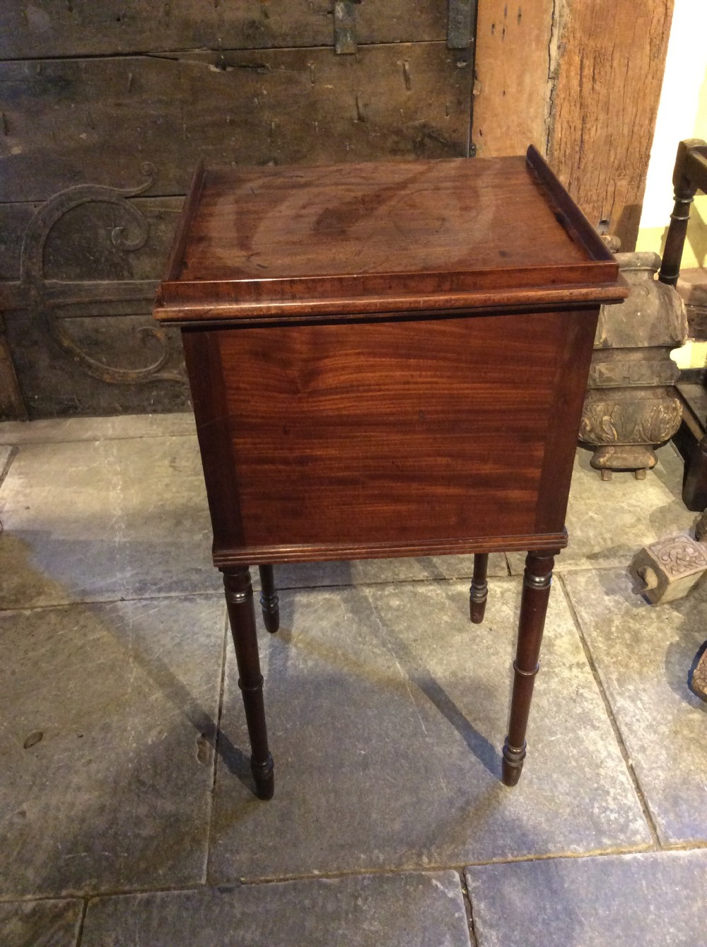 A Regency mahogany bedside cabinet featuring a gallery top, single flame mahogany door panel, and slender turned legs. View III