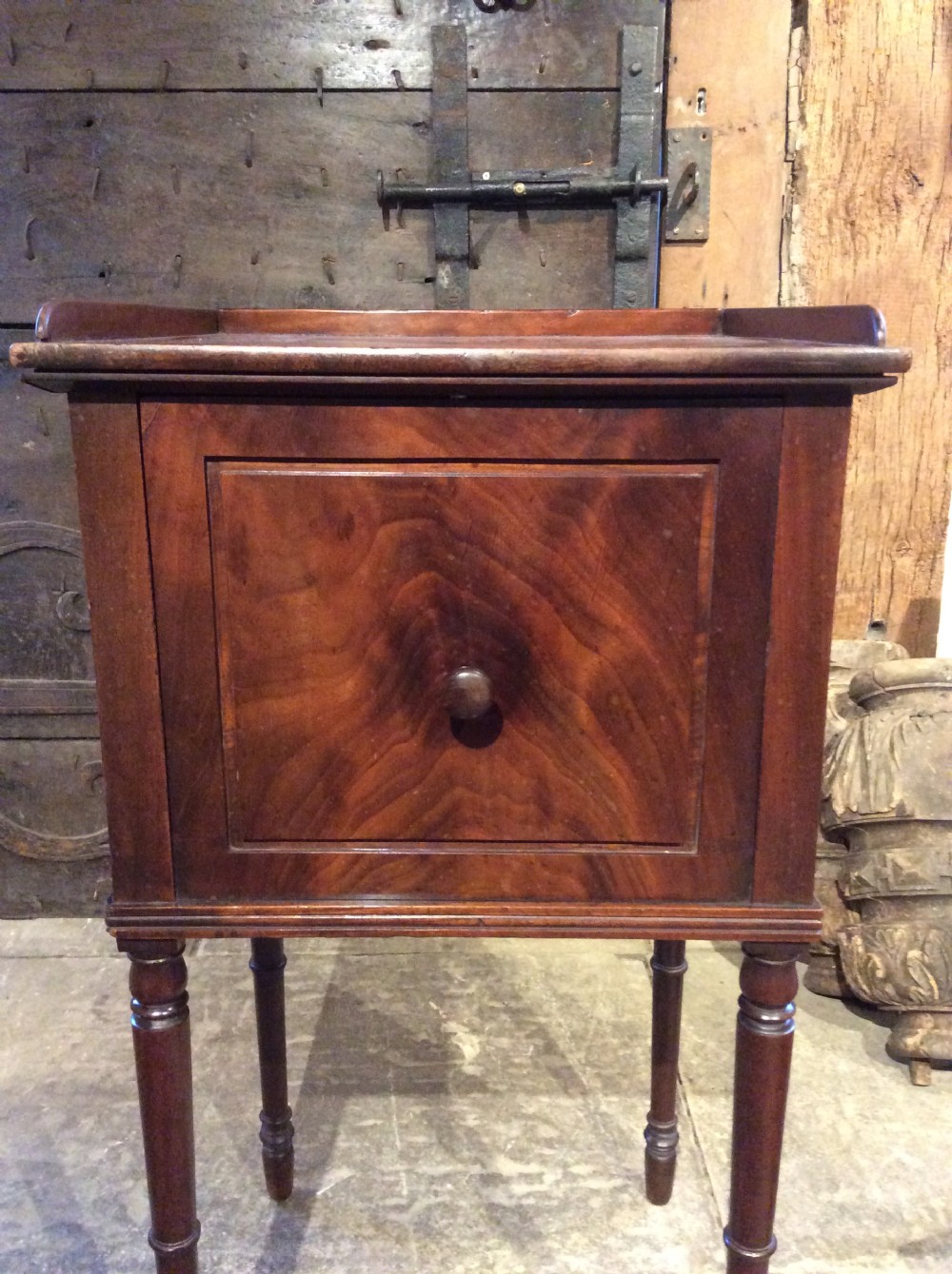 A Regency mahogany bedside cabinet featuring a gallery top, single flame mahogany door panel, and slender turned legs. View V
