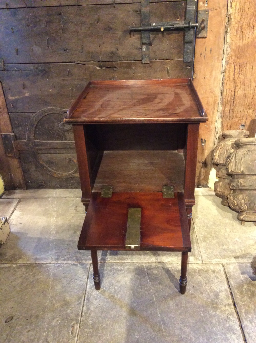 A Regency mahogany bedside cabinet featuring a gallery top, single flame mahogany door panel, and slender turned legs. View VIII