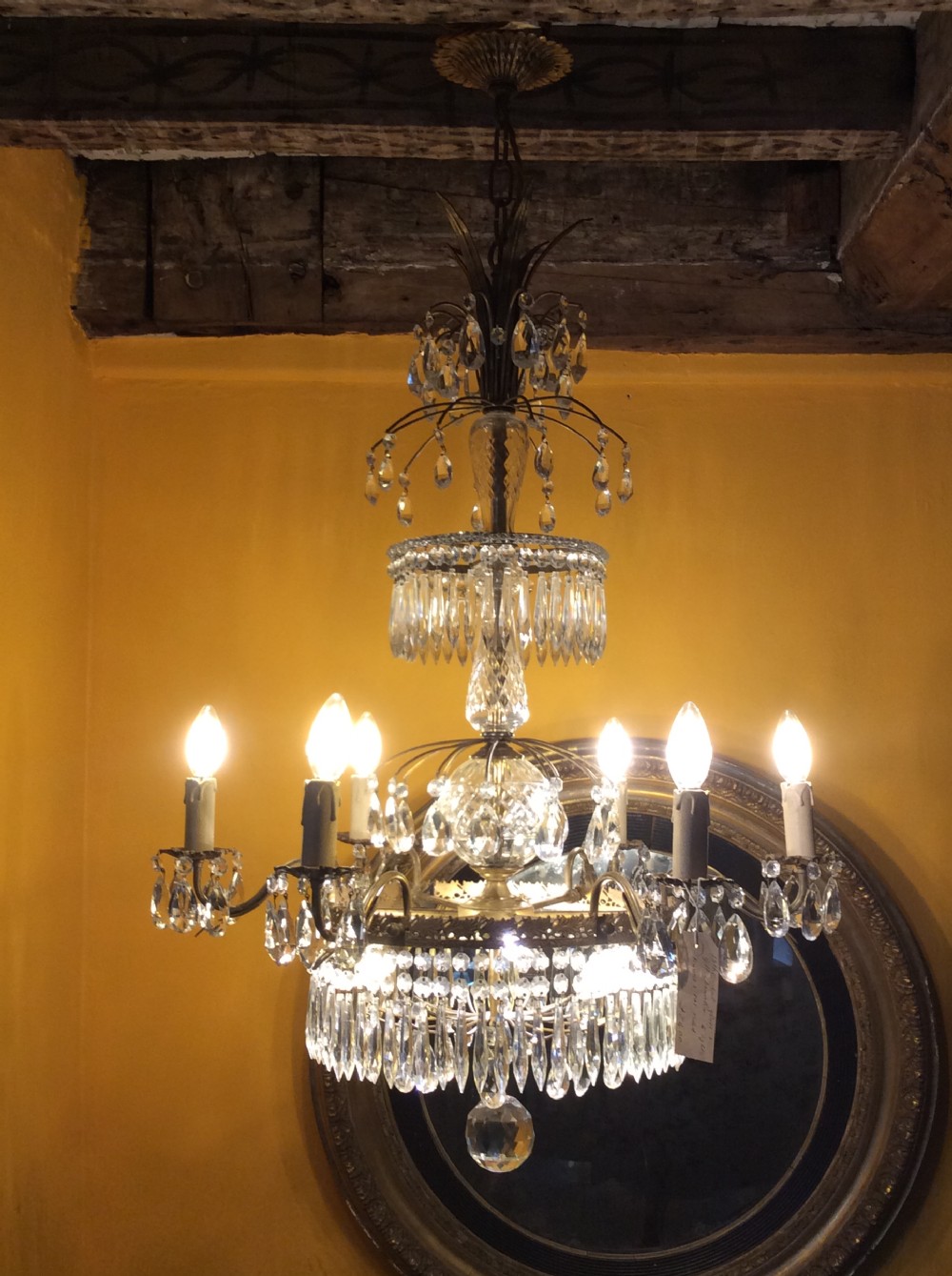 A nineteenth-century nine-branch chandelier featuring faceted cut glass drops, a central glass column, and gilt metal branches.