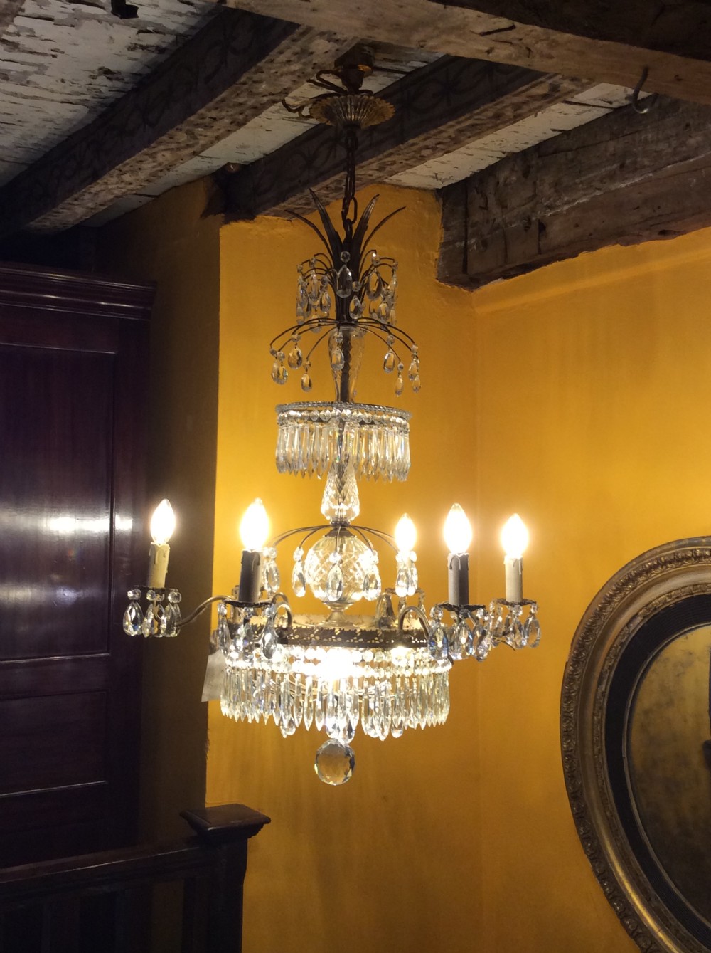 A nineteenth-century nine-branch chandelier featuring faceted cut glass drops, a central glass column, and gilt metal branches. View II