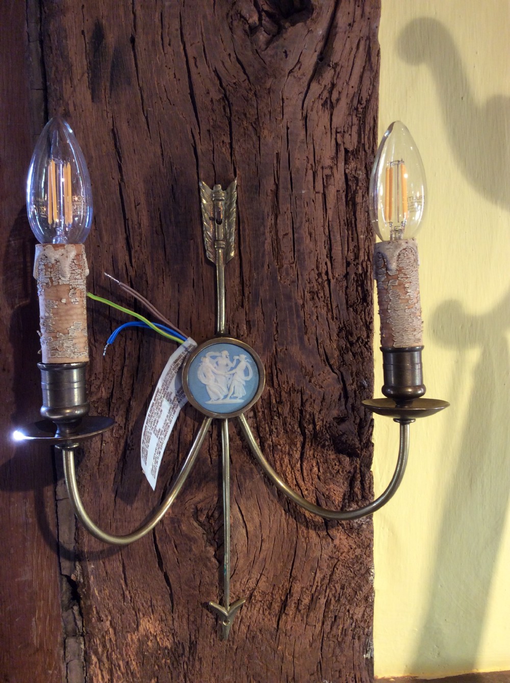 A pair of Edwardian brass twin-arm wall sconces featuring arrow motifs and circular blue jasperware medallions displaying white classical figures. View IV