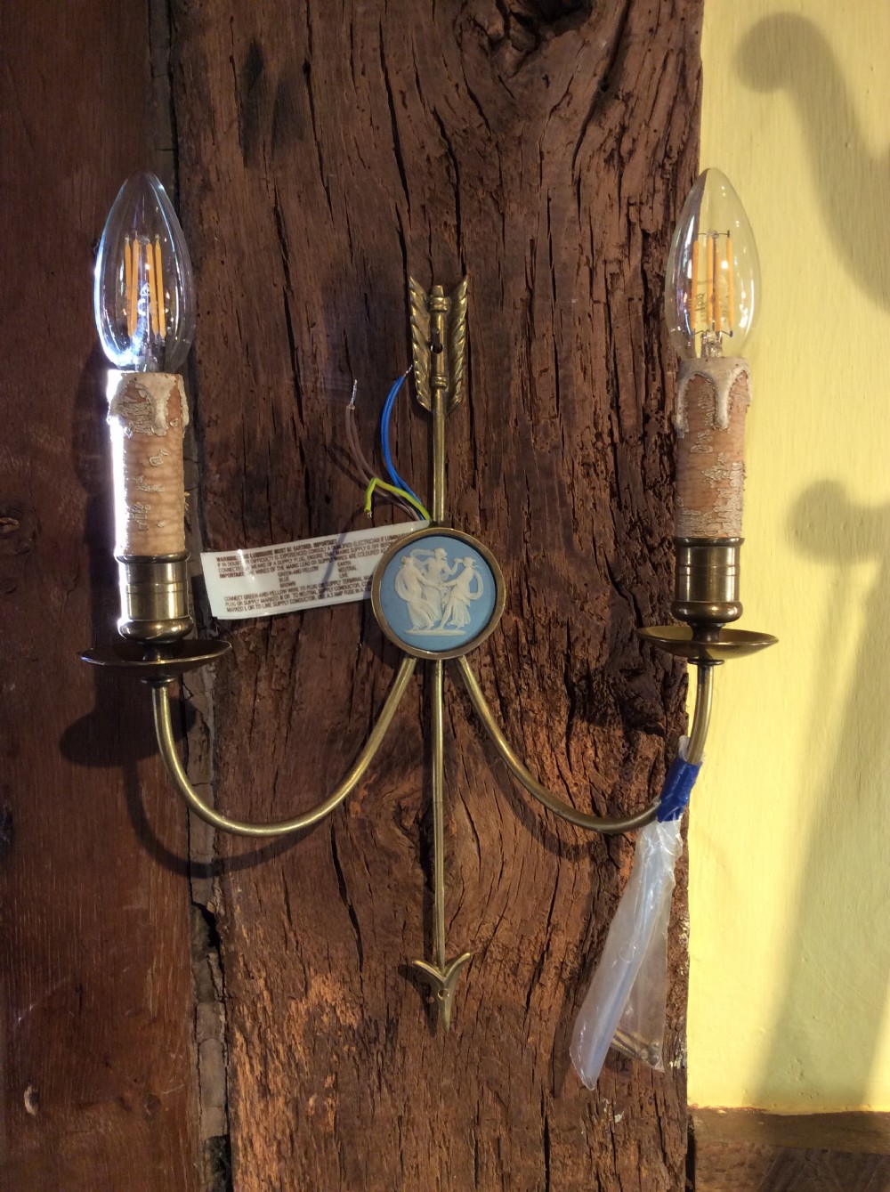 A pair of Edwardian brass twin-arm wall sconces featuring arrow motifs and circular blue jasperware medallions displaying white classical figures. View V