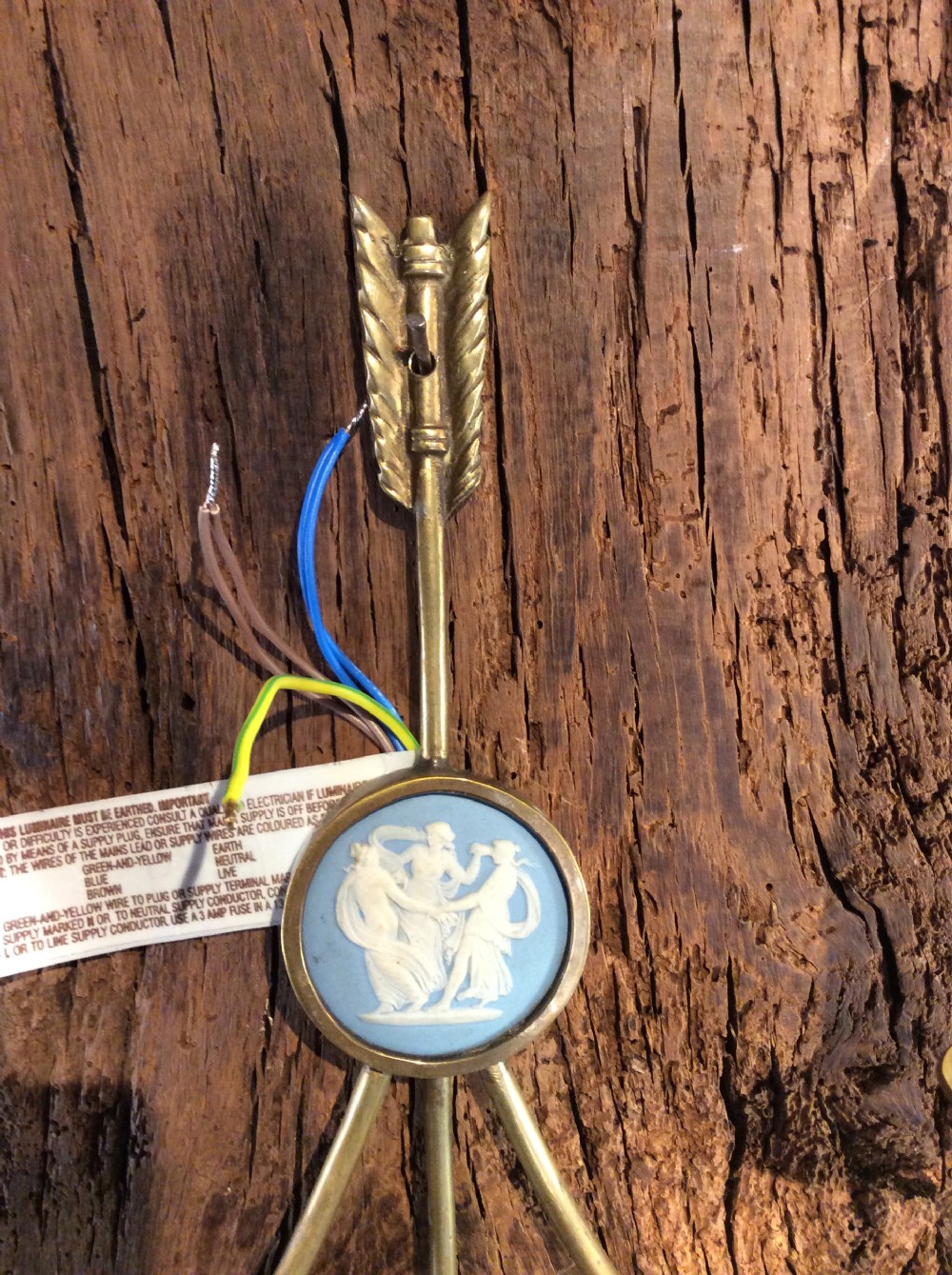 A pair of Edwardian brass twin-arm wall sconces featuring arrow motifs and circular blue jasperware medallions displaying white classical figures. View VI