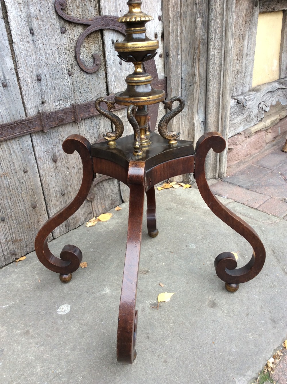 A 19th-century mahogany pole screen converted into a floor lamp featuring a slender turned shaft, gilt brass collars, and a scrolled tripod base. View II