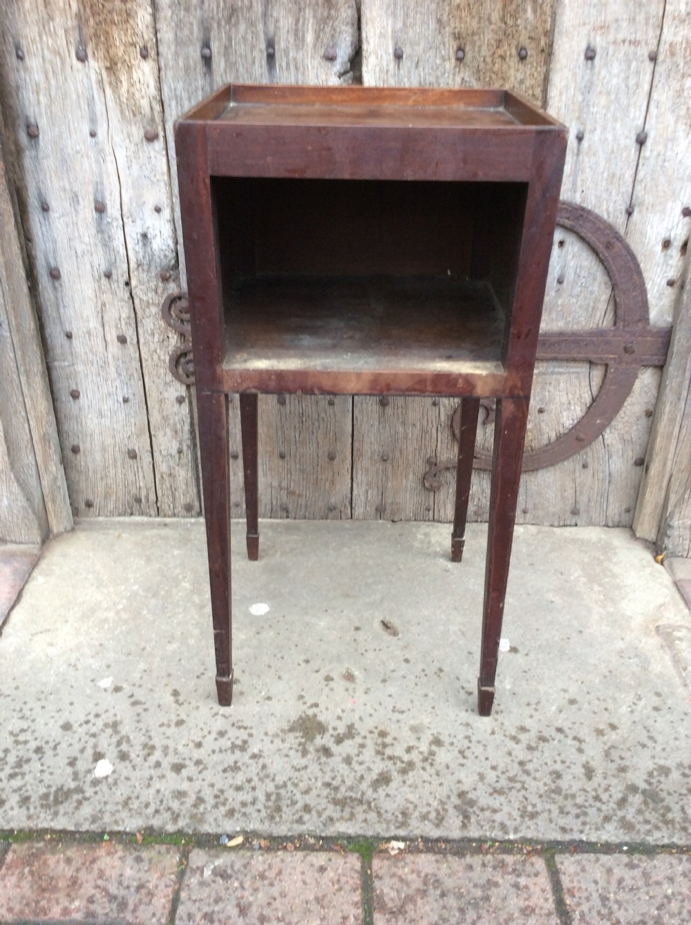 An 18th-century Georgian mahogany book table featuring a tray top gallery, an open compartment, and slender square tapered legs.