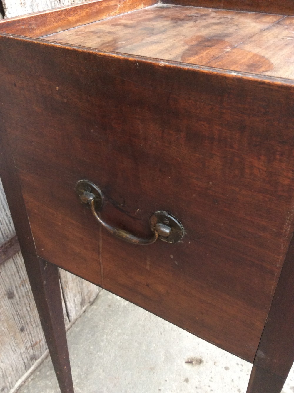 An 18th-century Georgian mahogany book table featuring a tray top gallery, an open compartment, and slender square tapered legs. View V