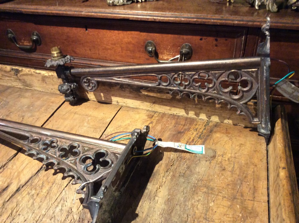 A pair of patinated dark brass Victorian Gothic wall light brackets featuring openwork tracery with trefoil motifs and detailed cast collars. View VI