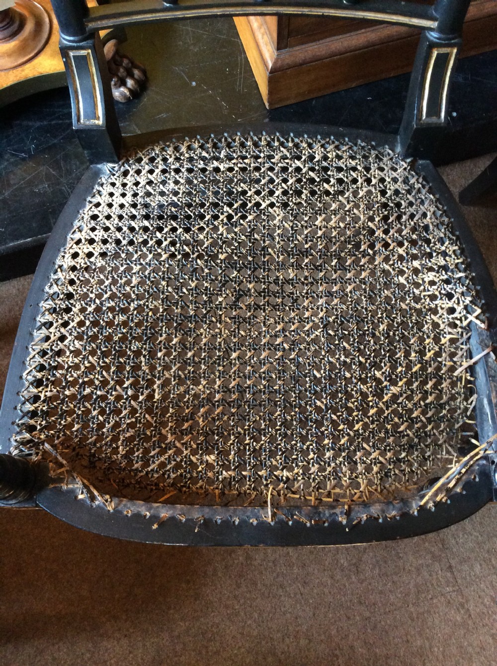 A pair Regency Ebonised caned chairs View II