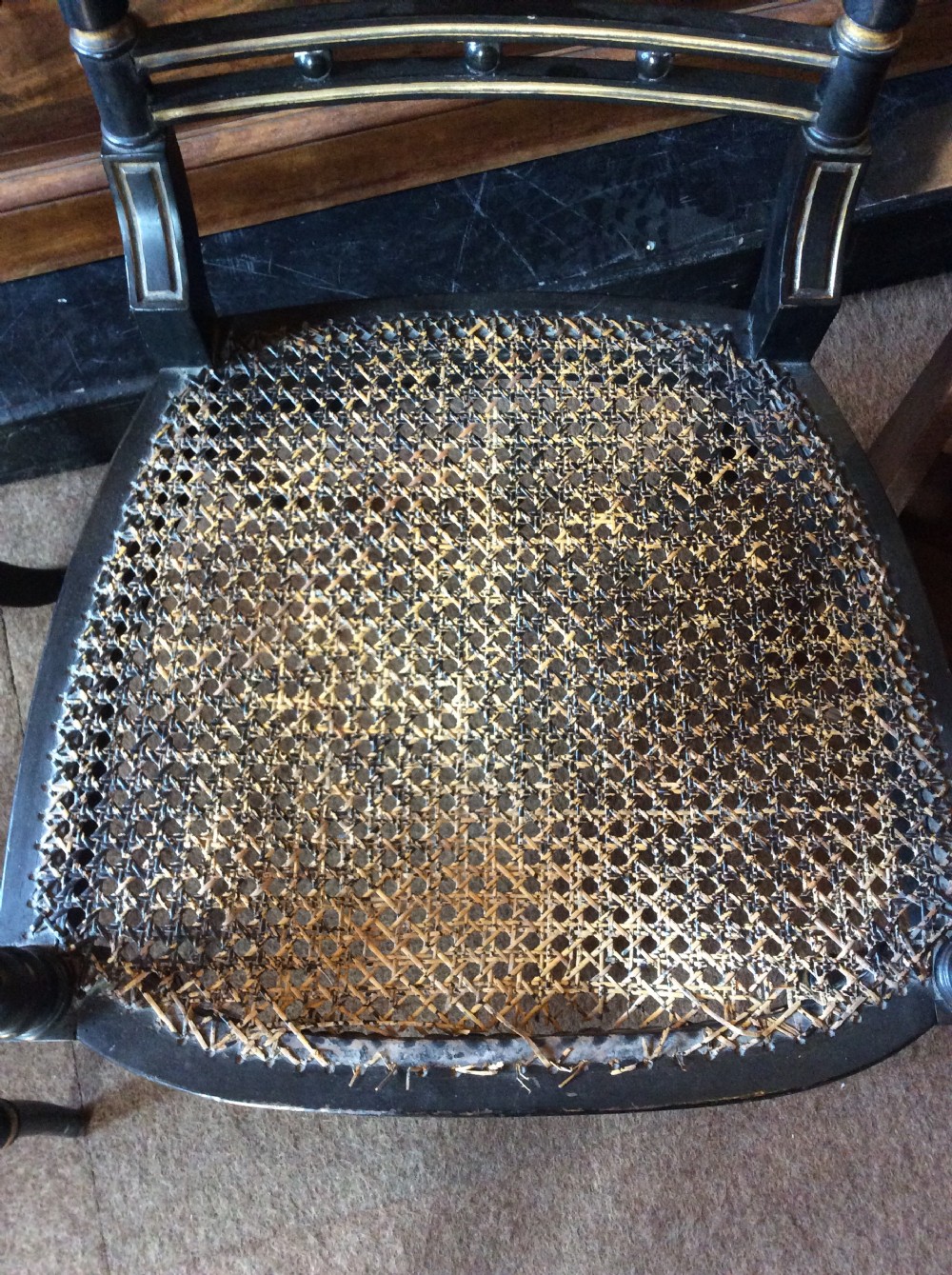 A pair Regency Ebonised caned chairs View V