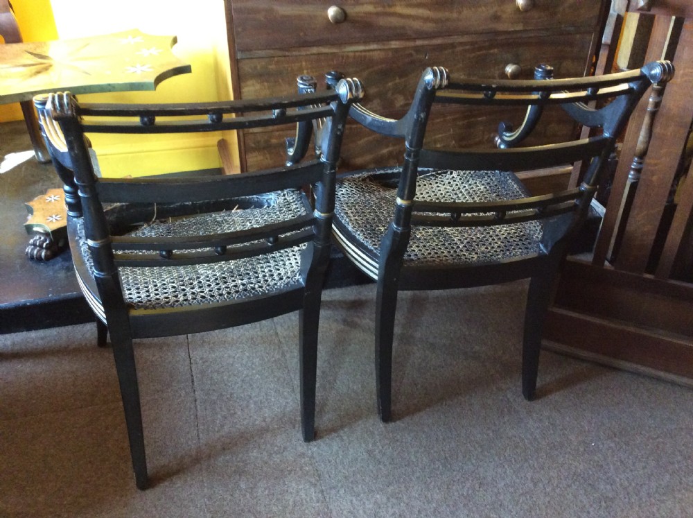 A pair Regency Ebonised caned chairs View VII