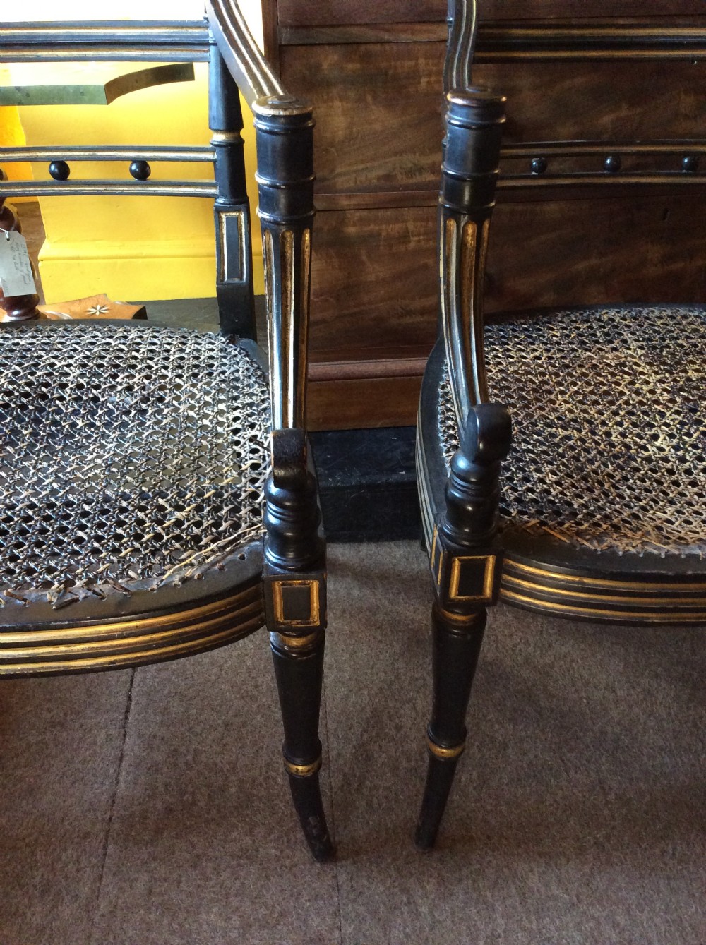 A pair Regency Ebonised caned chairs View VIII