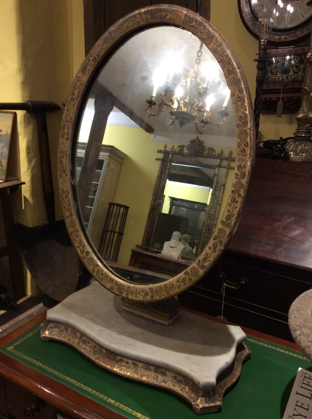 Decorated tilting table mirror on marble plinth