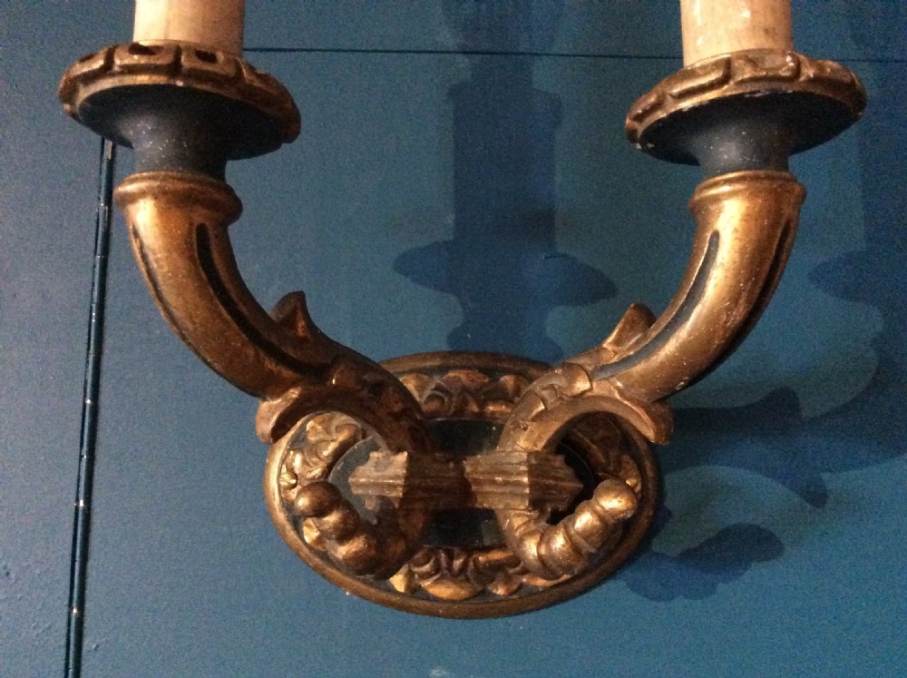 A pair of 19th-century carved and gilded twin-arm wall light brackets featuring faux candle sleeves and decorative scrollwork. View VI
