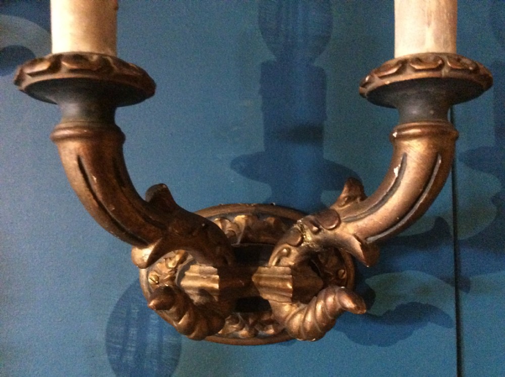 A pair of 19th-century carved and gilded twin-arm wall light brackets featuring faux candle sleeves and decorative scrollwork. View VII