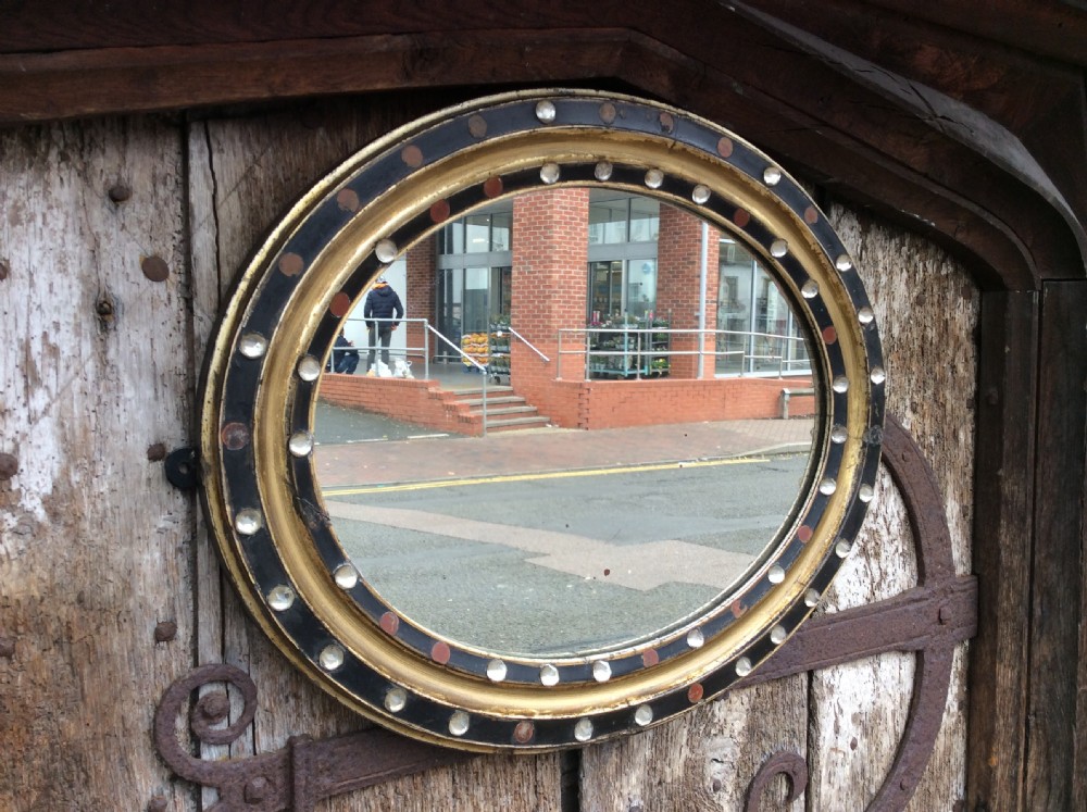 A 19thC oval Irish mirror with ebonised & gilded frame