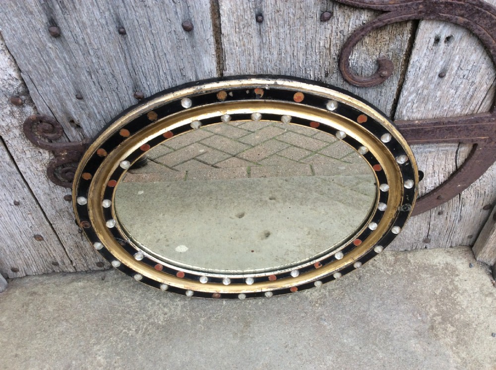 A 19thC oval Irish mirror with ebonised & gilded frame View III