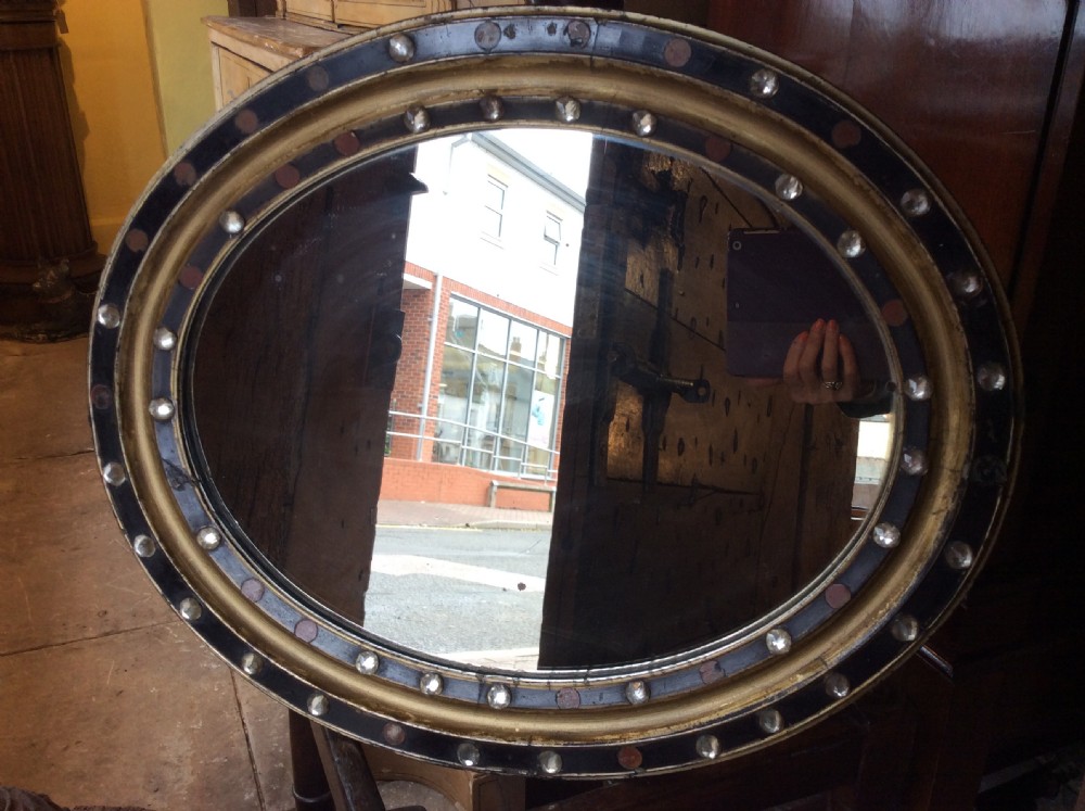 A 19thC oval Irish mirror with ebonised & gilded frame View V