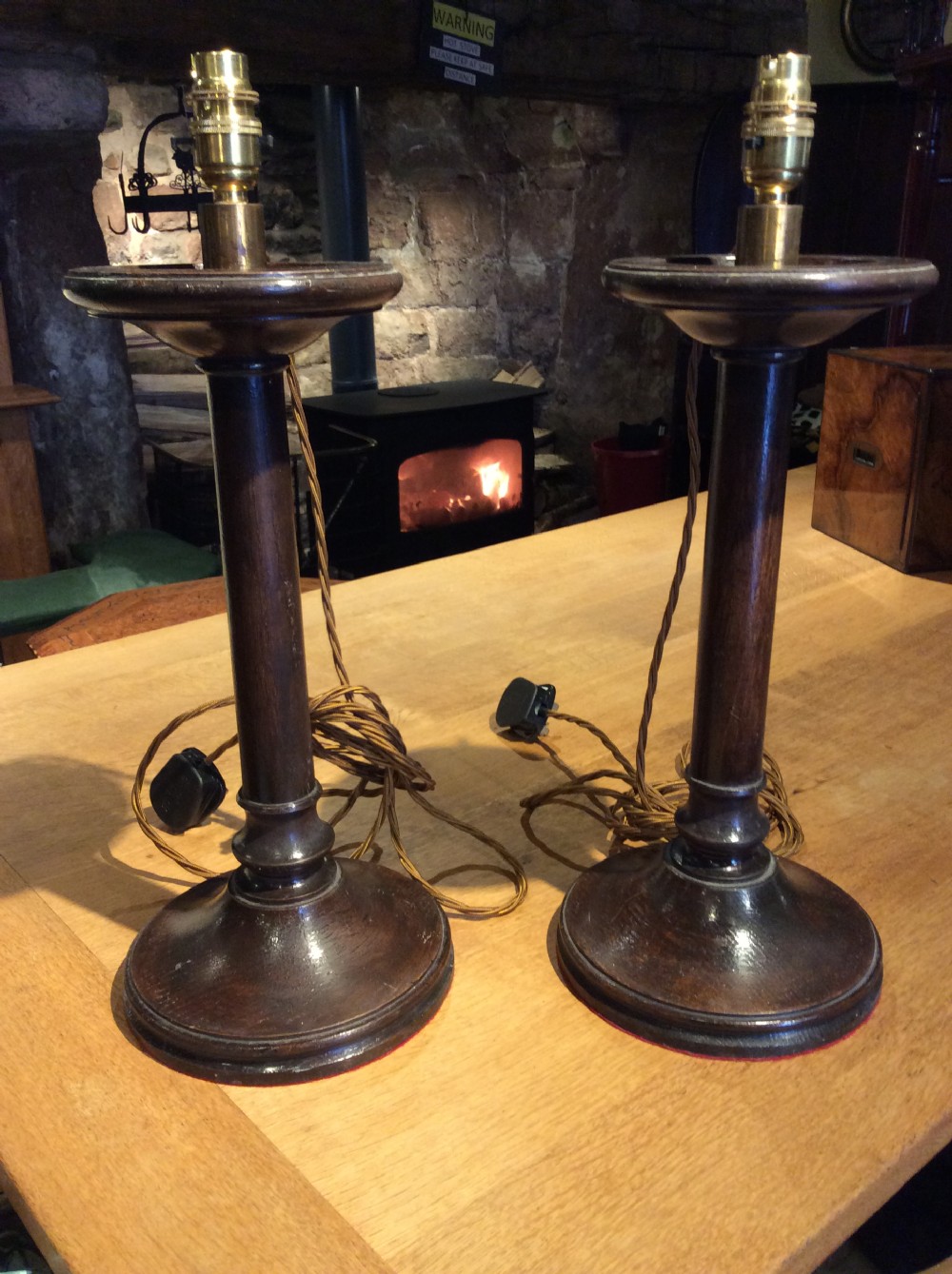 A pair of Edwardian candlestick oak lamps