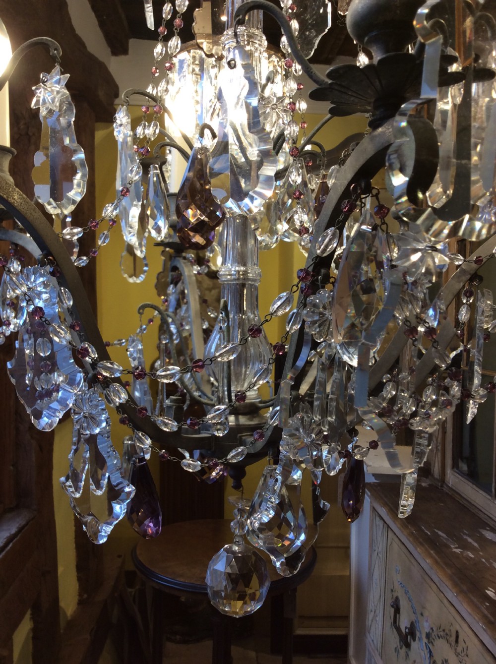 A nineteenth-century six-light chandelier featuring a central cut-glass baluster, curved metal arms, candle-style bulb holders, and cascading crystal drops. View II