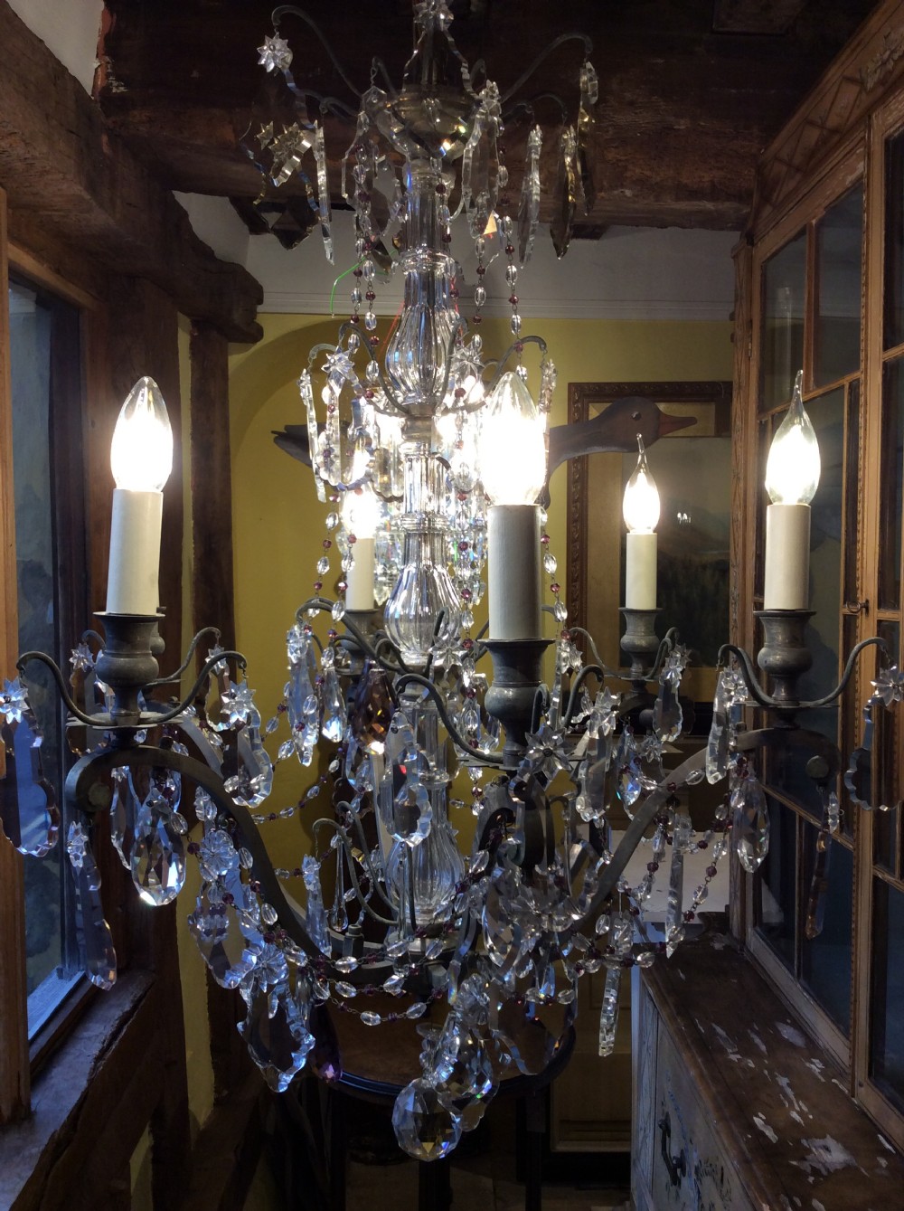 A nineteenth-century six-light chandelier featuring a central cut-glass baluster, curved metal arms, candle-style bulb holders, and cascading crystal drops. View III