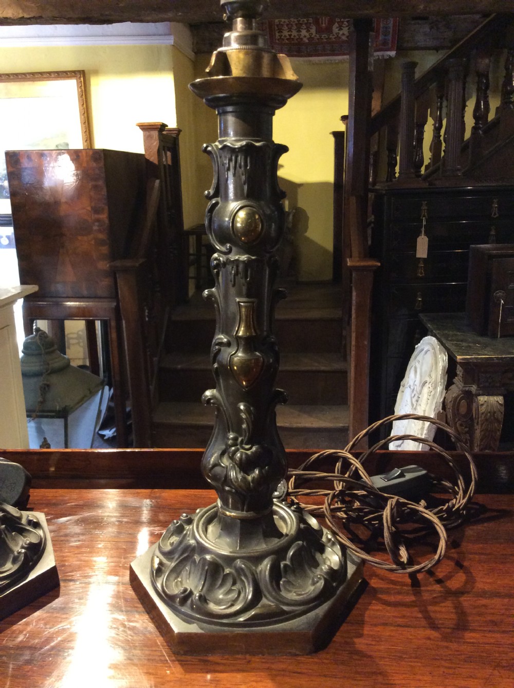 A pair of nineteenth-century repousse brass table lamps featuring ornate scrolling foliage stems on hexagonal bases. View II