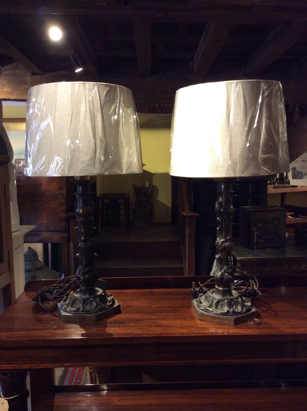 A pair of nineteenth-century repousse brass table lamps featuring ornate scrolling foliage stems on hexagonal bases. View VI
