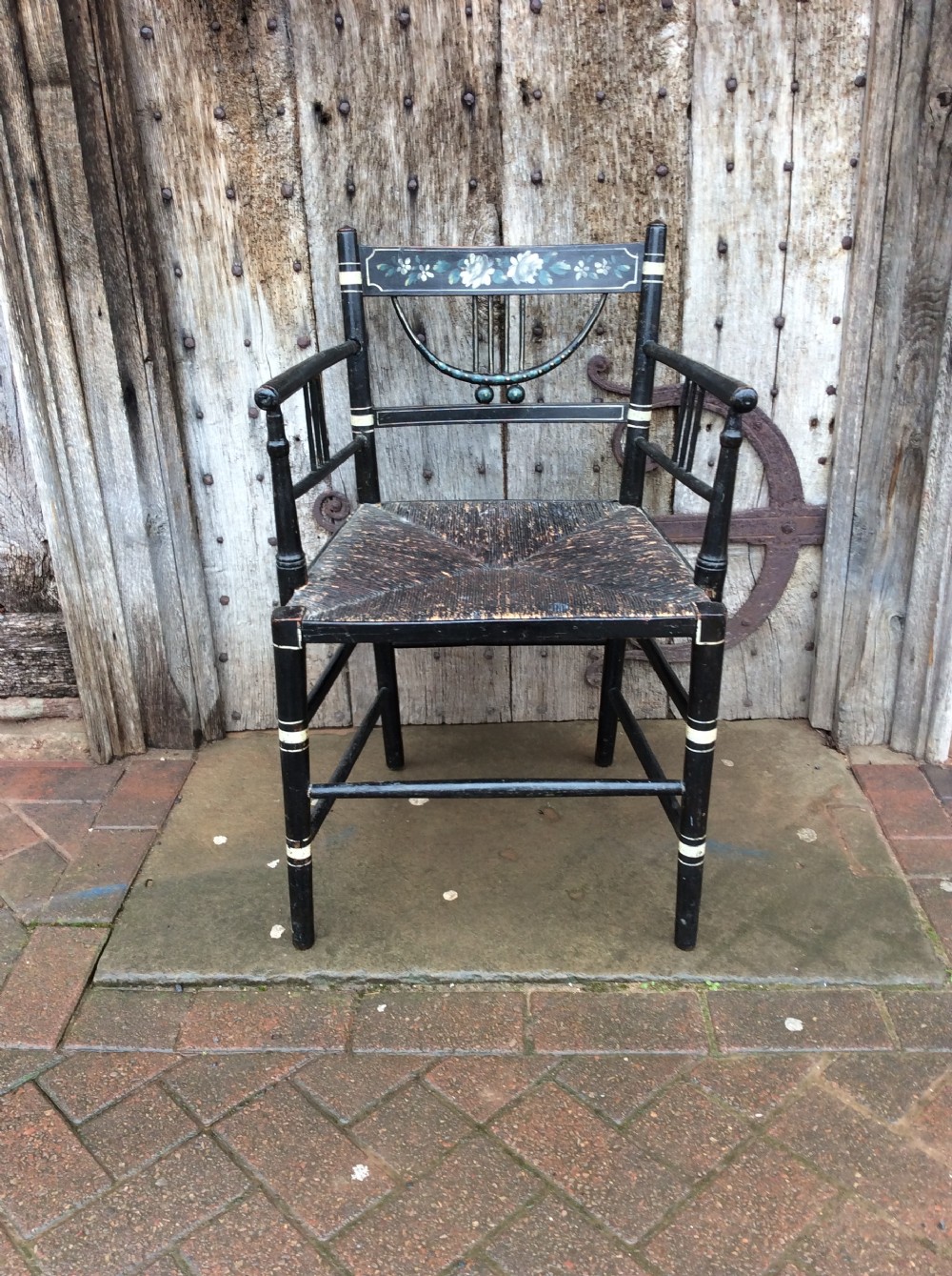 A Regency ebonised and decorated rush seated chair