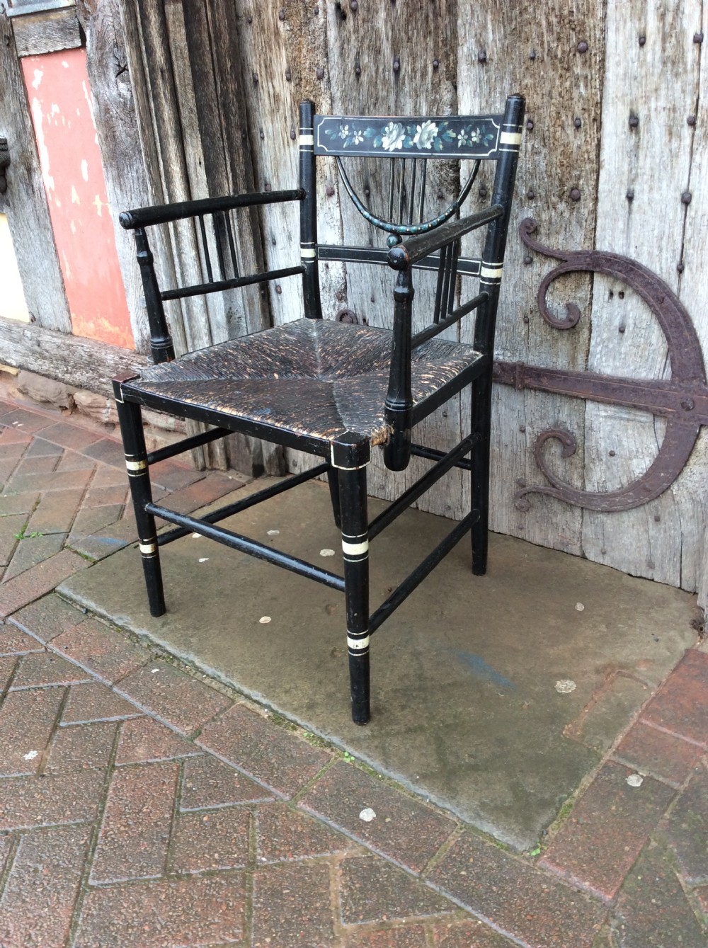 A Regency ebonised and decorated rush seated chair View II