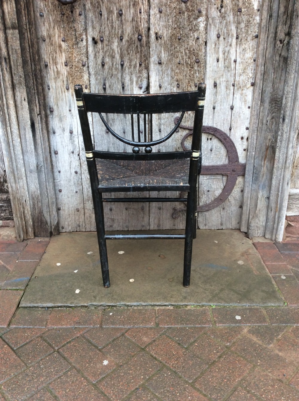 A Regency ebonised and decorated rush seated chair View V