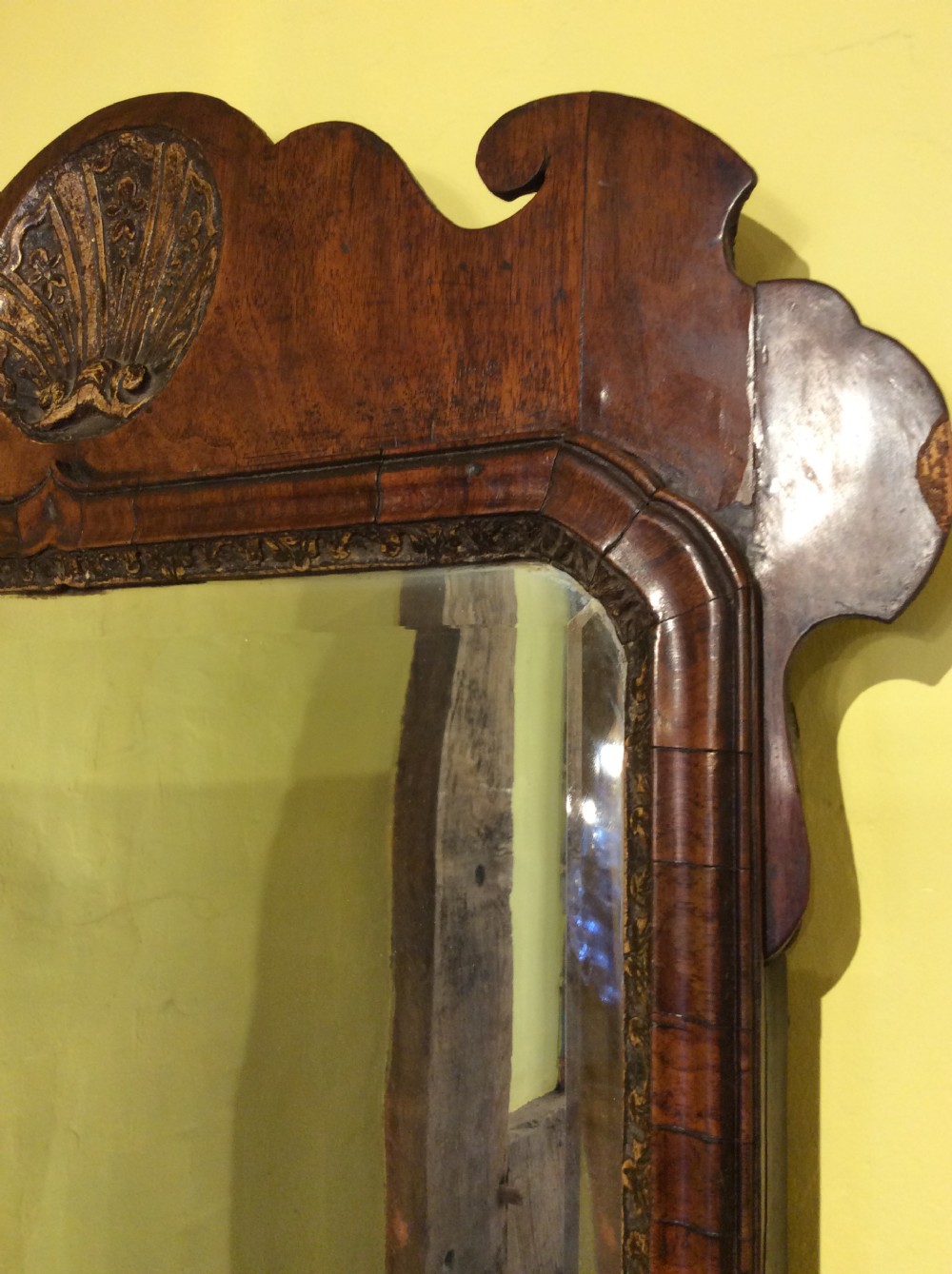 An 18th-century Queen Anne walnut wall mirror featuring a scroll-cut shaped apron and top cresting adorned with a carved gilt shell. View III