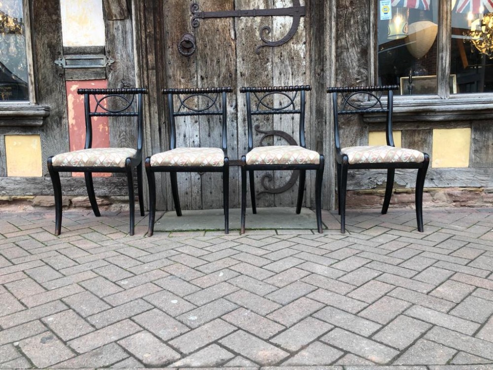 A set of four 19thC ebonised sabre leg chairs