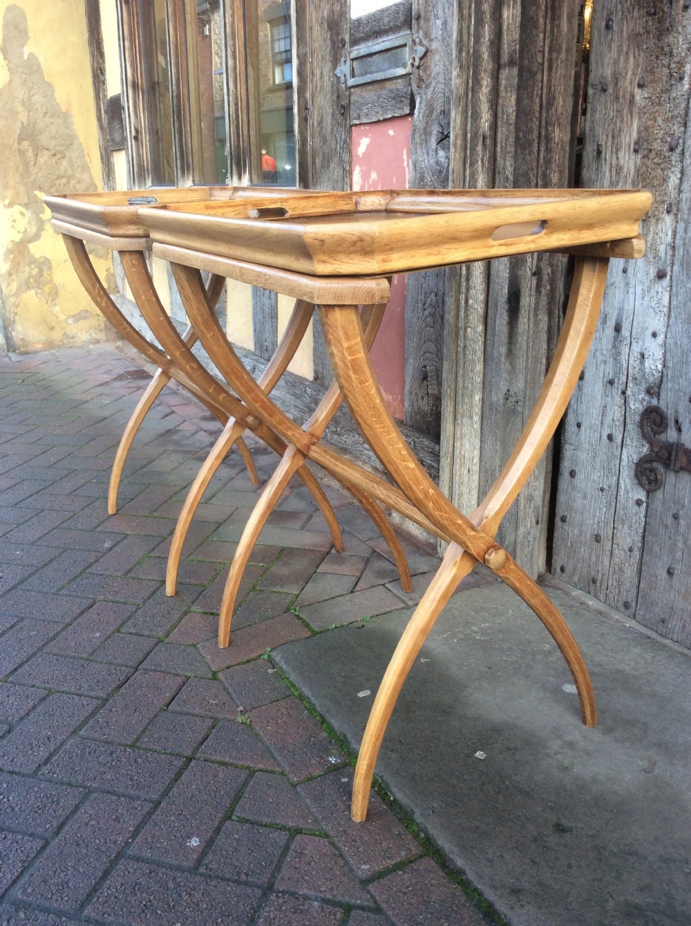 An early twentieth-century light oak butlers tray featuring cut-out handles, resting on a matching curved wooden stand. View V