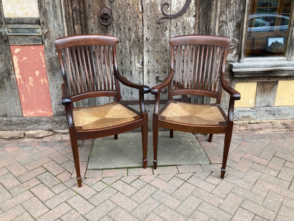 A pair of early 20th century mahogany rush-seated armchairs c 1910