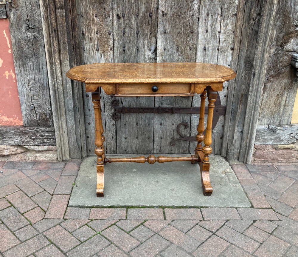 A 19th-century Hungarian ash side table featuring a single drawer with a dark knob, shaped aprons, and turned legs joined by a central stretcher. View II