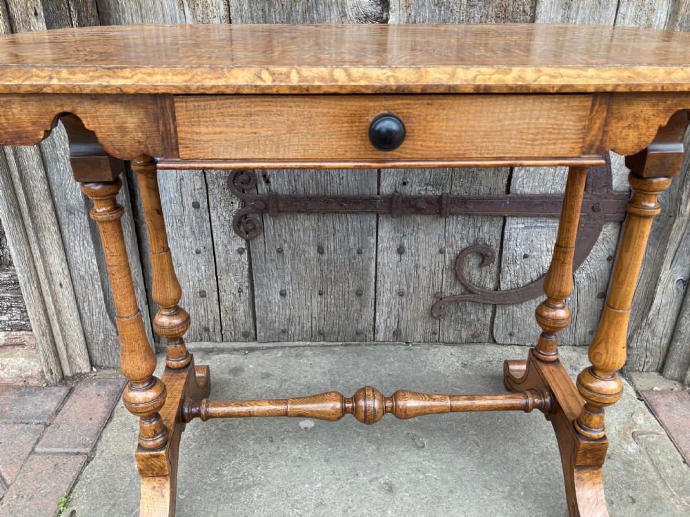 A 19th-century Hungarian ash side table featuring a single drawer with a dark knob, shaped aprons, and turned legs joined by a central stretcher. View V