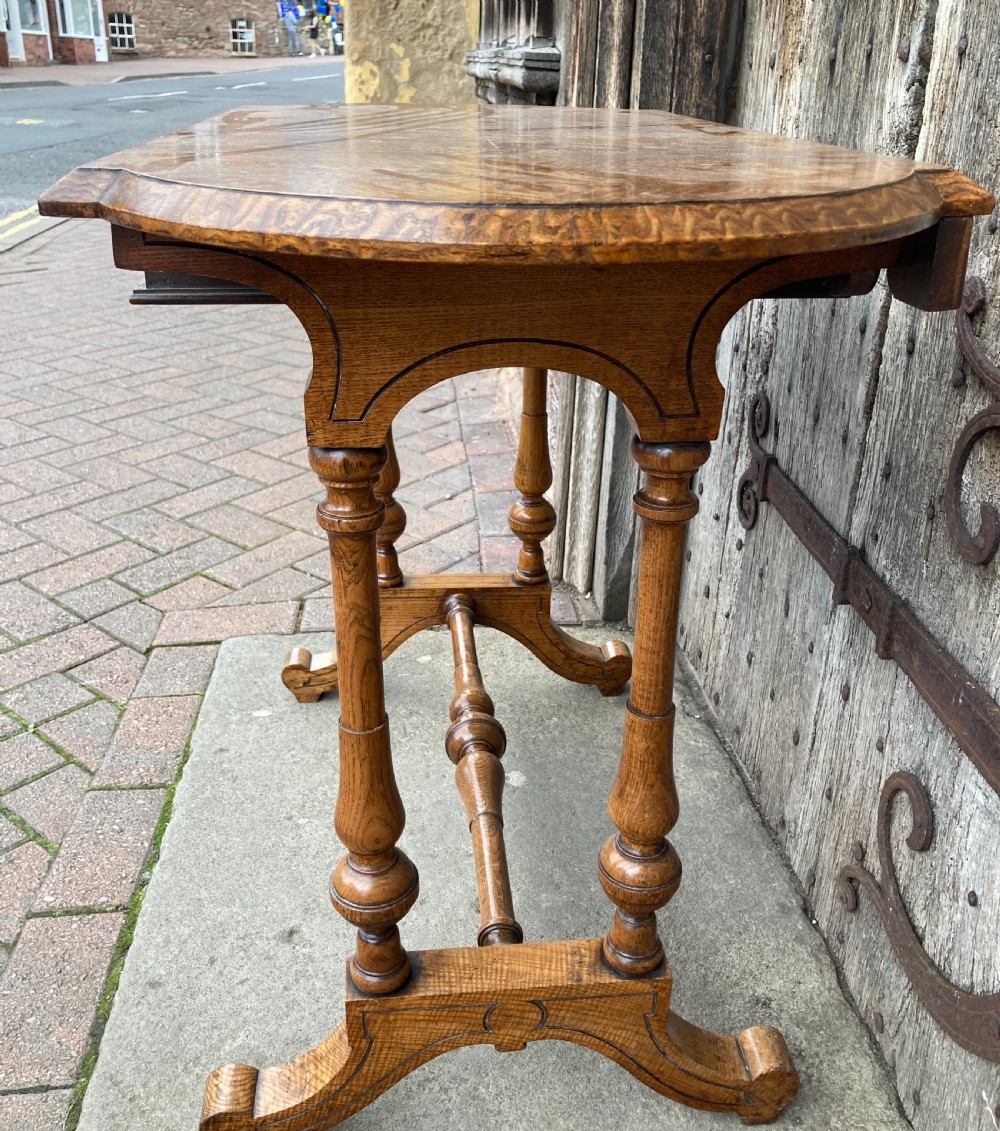 A 19th-century Hungarian ash side table featuring a single drawer with a dark knob, shaped aprons, and turned legs joined by a central stretcher. View X
