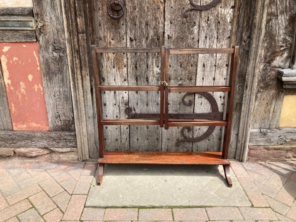 A nineteenth-century mahogany three-fold towel rail featuring horizontal drying bars, brass hinges, and a solid lower wooden shelf. View II