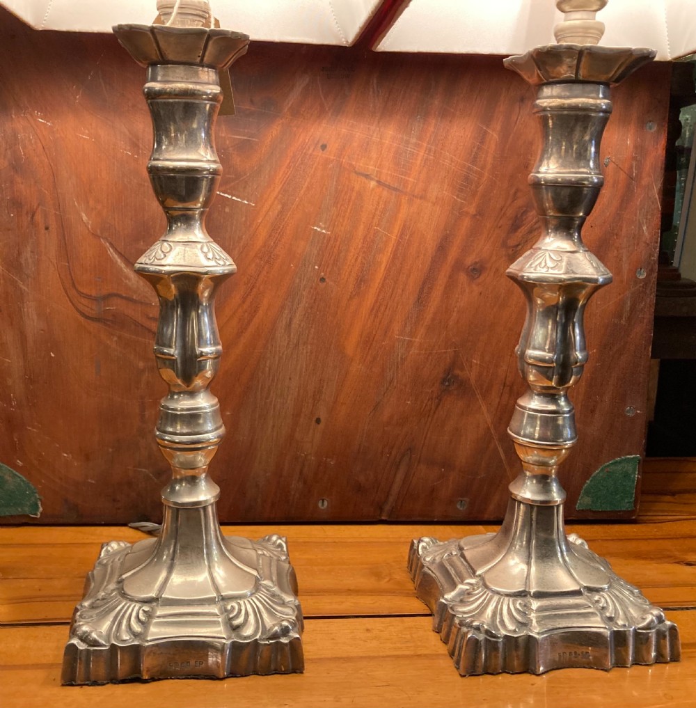 A pair of early twentieth-century silver-plated candlestick table lamps fitted with red pleated shades. View II