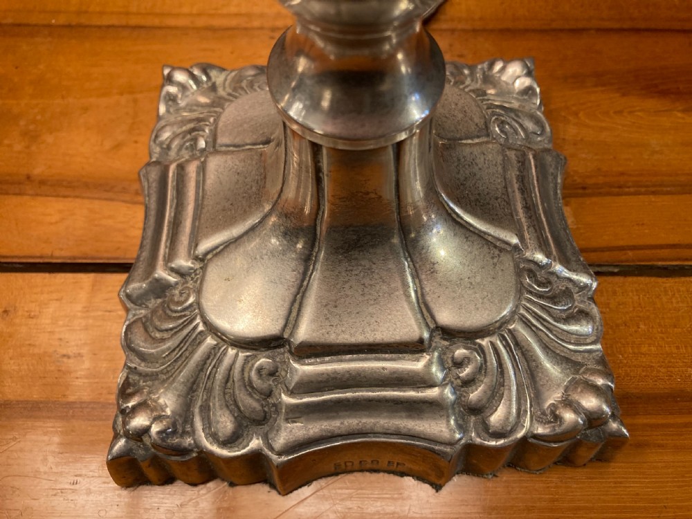 A pair of early twentieth-century silver-plated candlestick table lamps fitted with red pleated shades. View IV