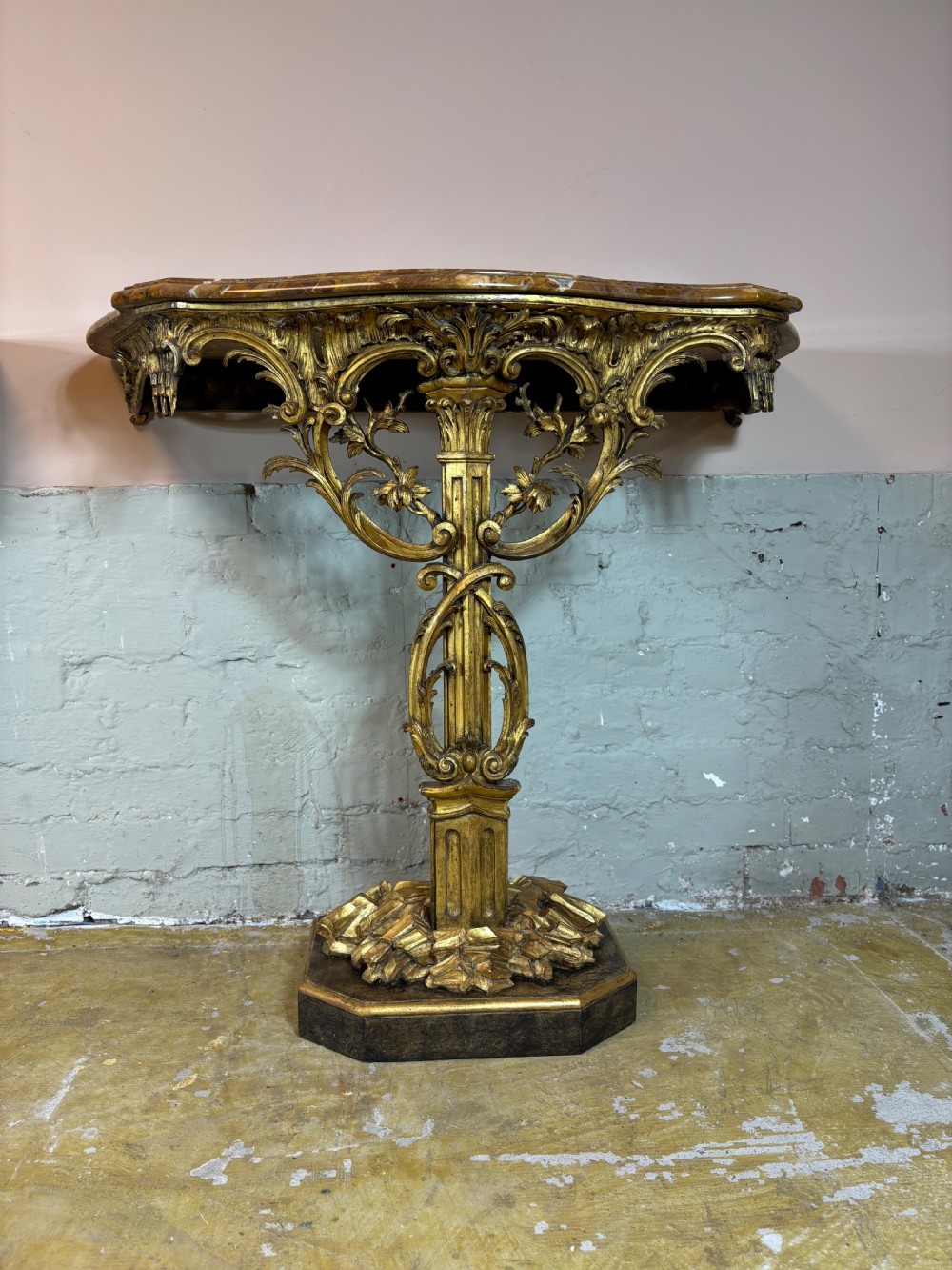 A pair of 18th-century carved giltwood side tables with openwork scrolling pedestal bases and marble tops. View II