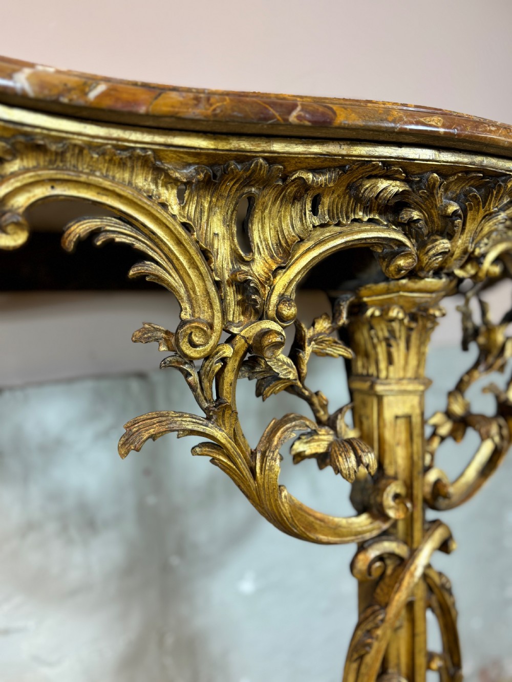 A pair of 18th-century carved giltwood side tables with openwork scrolling pedestal bases and marble tops. View IX