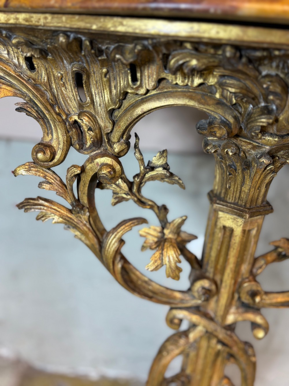 A pair of 18th-century carved giltwood side tables with openwork scrolling pedestal bases and marble tops. View XI