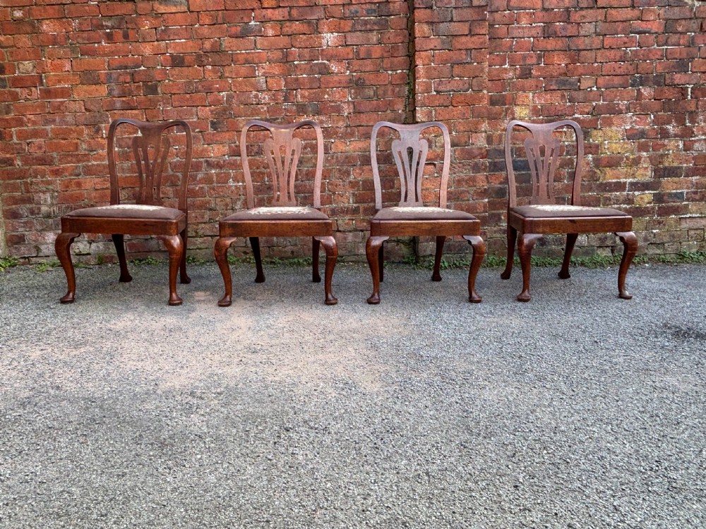 A set of four 18th-century George II walnut side chairs featuring carved splat backrests, patterned drop-in seats, and cabriole legs ending in pad feet. View VI